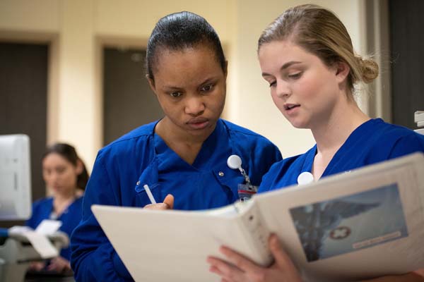 Certified Nurse Aide Students Reviewing Chart