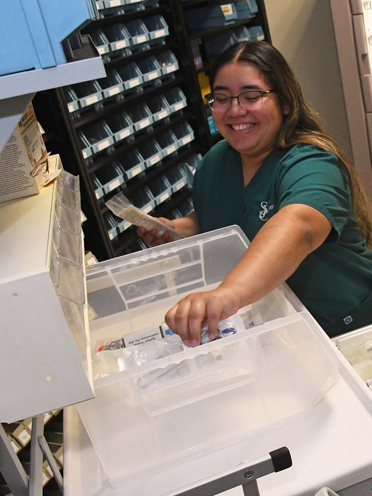 pharmacy tech sorting thorugh medicine in drawer